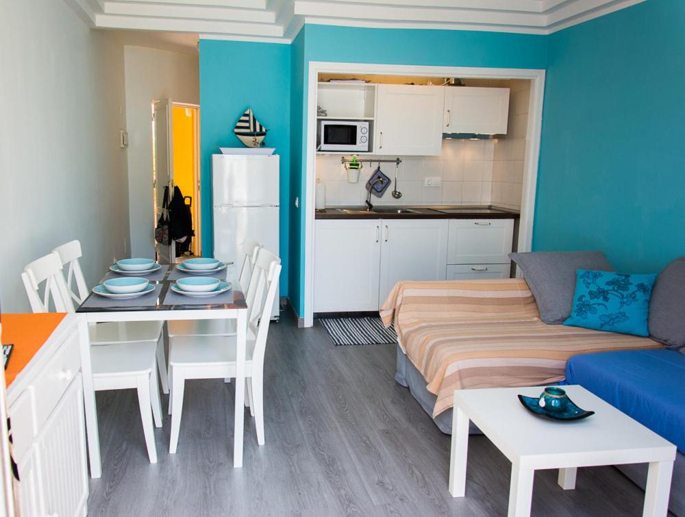 sala de estar con sofá, mesa y cocina en Apartment Playa Torviscas, en Adeje