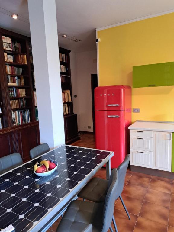 a kitchen with a table and a red refrigerator at Book Paradise in Cremona