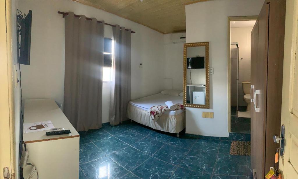 a small room with a bed and a mirror at Hotel Raiz in Manaus