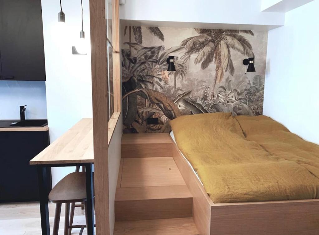Un dormitorio con una cama y una mesa en una habitación. en Architect Studio Moulin Rouge, en París