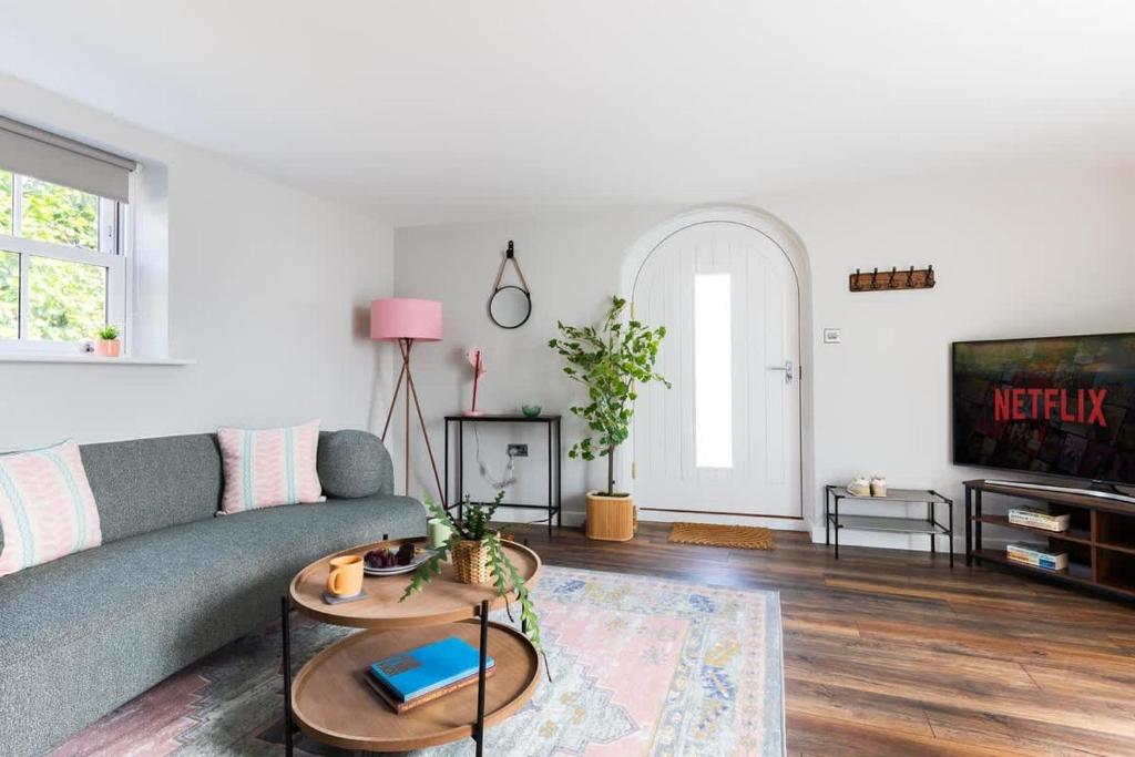 a living room with a couch and a tv at Ivy Mews - Converted Barn in Popular Village in Scarborough
