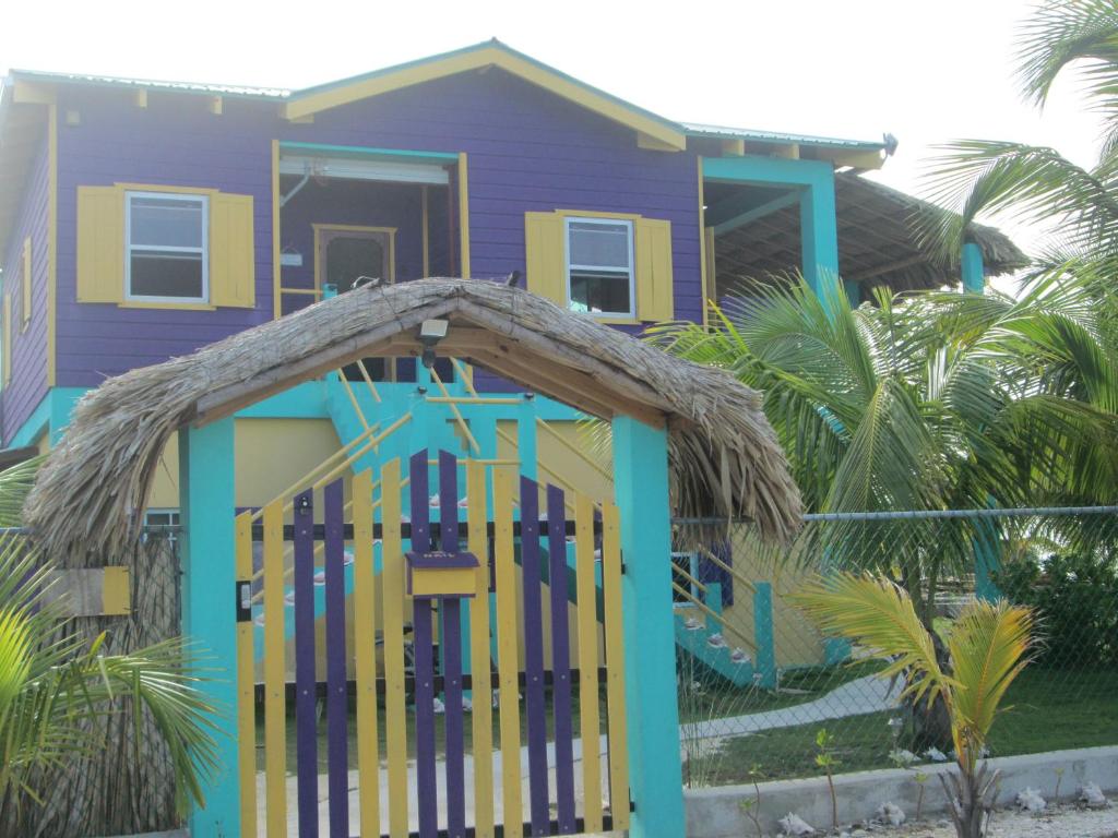 a purple house with a colorful door in front of it at SLO-N-EZ Villa- Gold Standard Certified in Caye Caulker