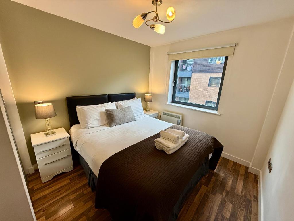 a bedroom with a large bed and a window at Bloom Apartments - City Centre - Gated Parking in Manchester