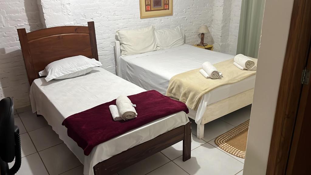 una camera da letto con due letti con asciugamani sopra di Pousada Campina do Monte Alegre a Campina do Monte Alegre