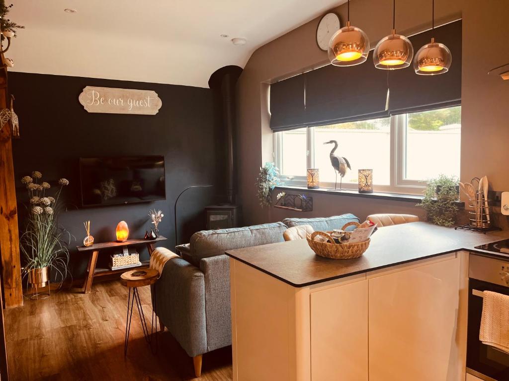 a living room with a couch and a kitchen at TyCosy in St. Davids