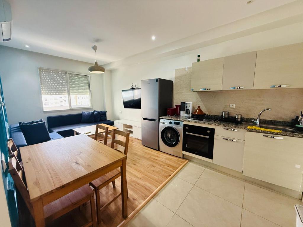 a kitchen and dining room with a table and a dining room at Chic appartement agadir with pool&balcony in Agadir
