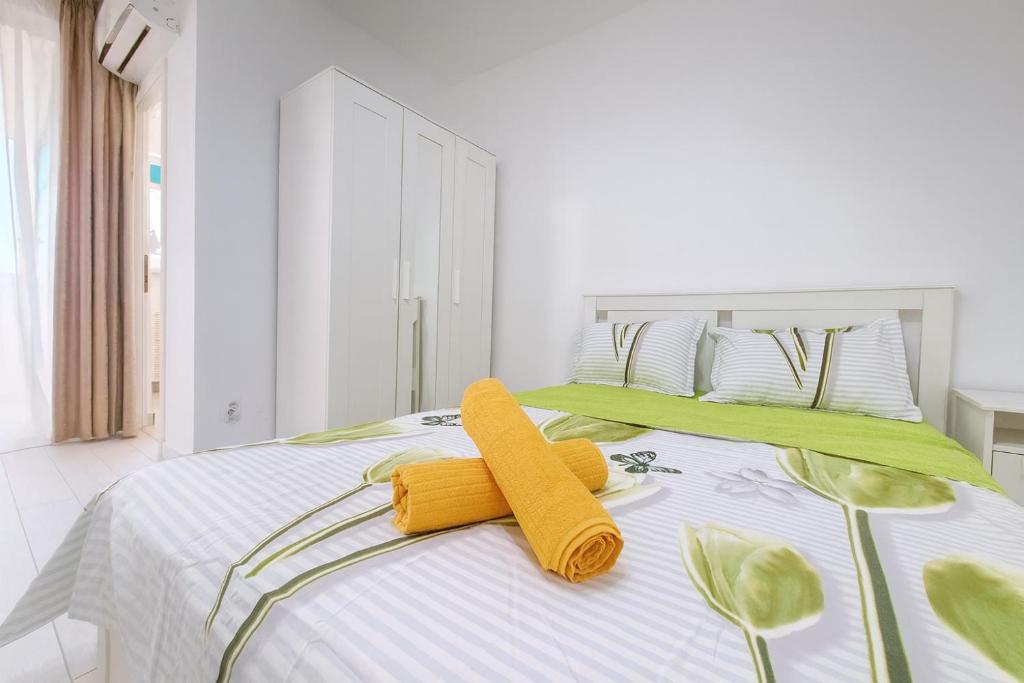 ブカレストにあるSouth Pearl Studioの白いベッドルーム(黄色いタオルが付いたベッド付)