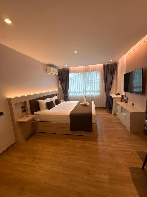 a bedroom with a bed and a flat screen tv at Spacious Bedroom- 2 mins from Train Station in Bangkok