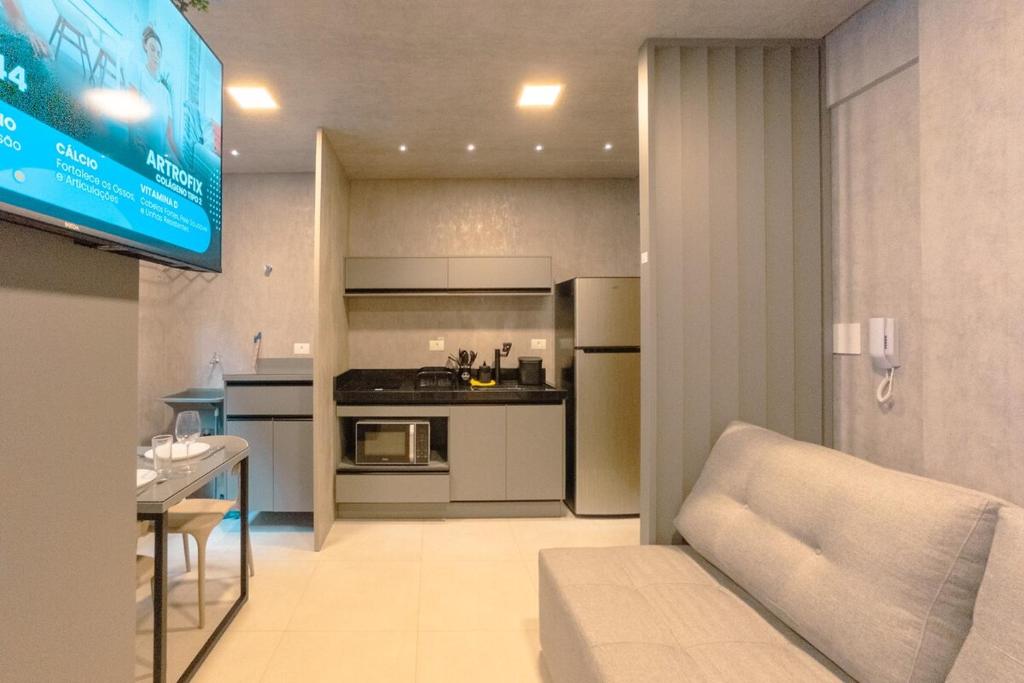 a kitchen with a couch and a tv in a room at Click e se encante! - GS203 in Maringá