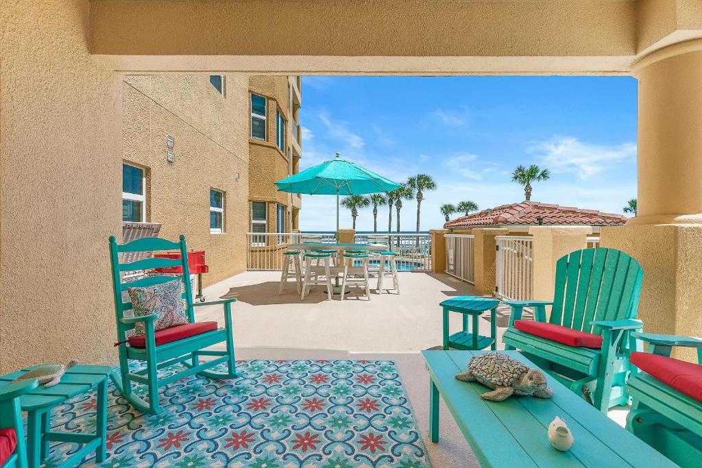 a patio with chairs and tables and an umbrella at Atlantic Villas 102 in Chicken Island