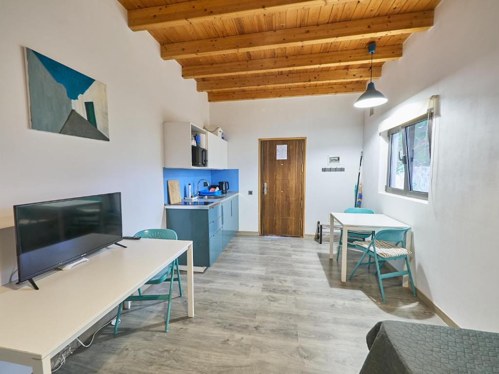 a room with a table and chairs and a kitchen at Los Lagos in El Roque