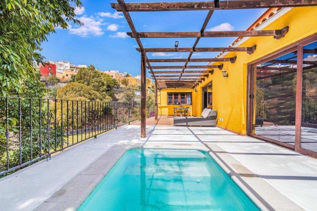 an indoor swimming pool in a backyard with a house at Una Casa Canaria Moderna in Ingenio