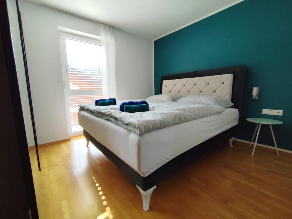 una camera da letto con un letto grande con una parete blu di Bella Vista Ferienwohnung a Bürs