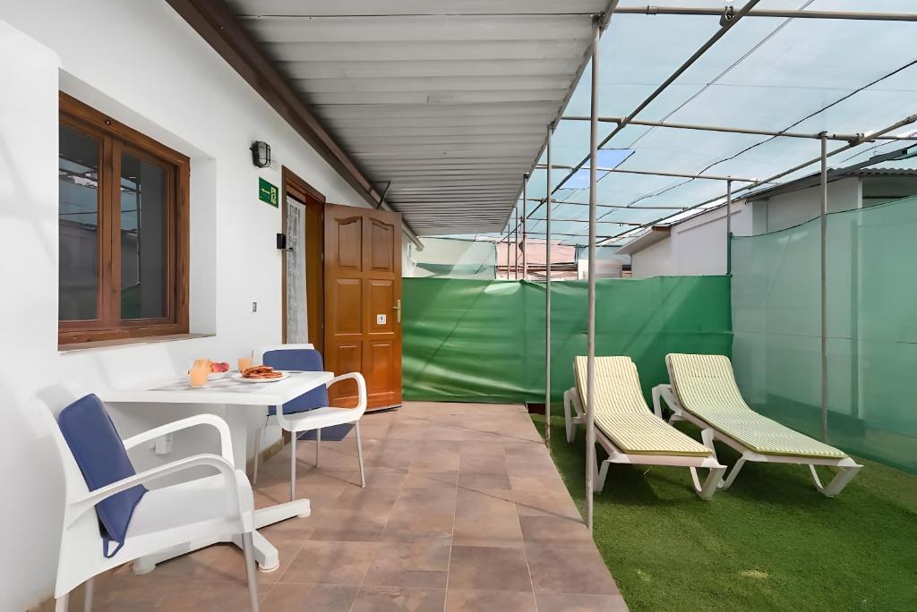 Zimmer mit einem Tisch, Stühlen und einer grünen Wand in der Unterkunft Country Studio Near Fataga in Artedara