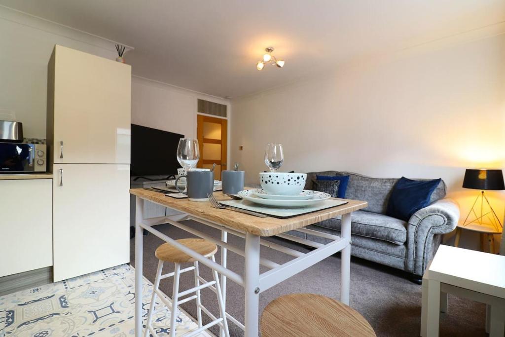 a kitchen and living room with a table and a couch at Cosy 1 bed flat in central Ayr in Ayr