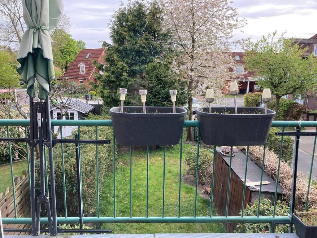 trois jardinières sur une clôture dans un jardin dans l'établissement Spacious 3 bedroom house in Norderstedt-Hamburg, à Norderstedt