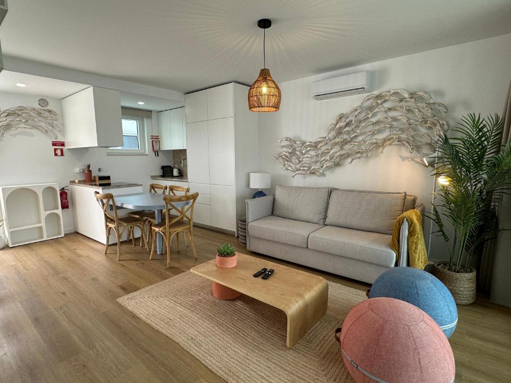 un soggiorno con un divano e un tavolo di WHome Cozy Riverside Apartment in Trafaria a Trafaria