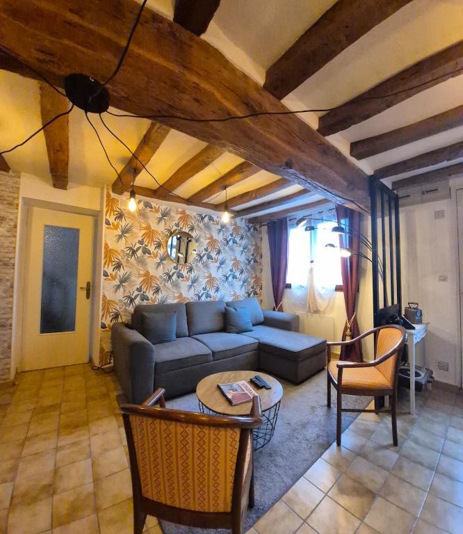 a living room with a couch and a table at Maison plein centre in Brain-sur-Allonnes