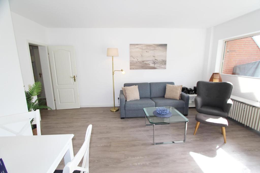 a living room with a couch and a table at Denghoog- Osetal 10, App 2 in Wenningstedt