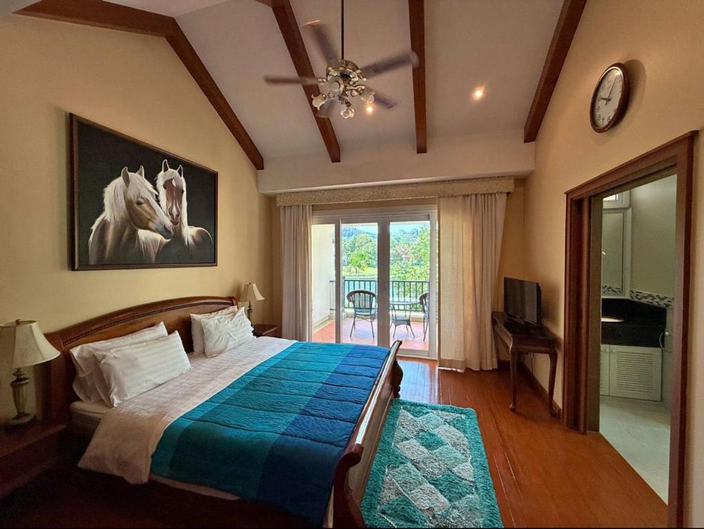 a bedroom with a bed and a window and a clock at 4 bedroom Villa with Private pool at Laguna in Angsana in Ban Thalat Choeng Thale