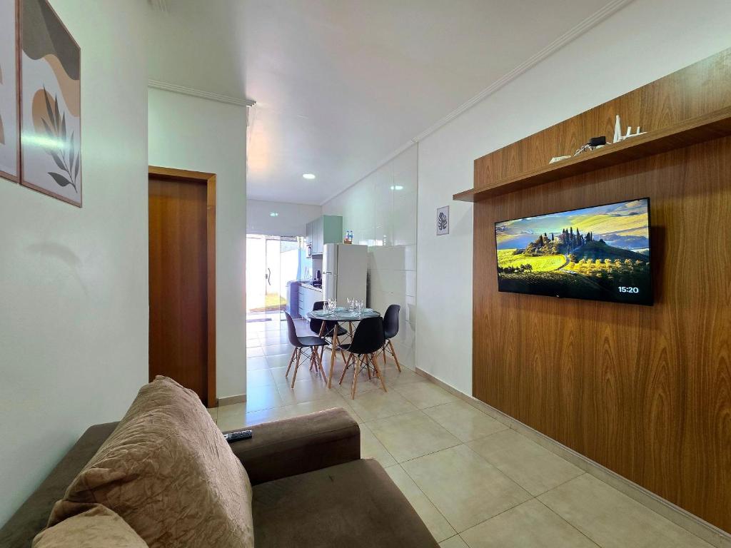 un soggiorno con un divano e una TV a parete di Casa 2 quartos prox centro, Argent, Marco 3 front a Foz do Iguaçu