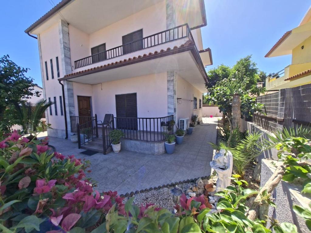 Una casa blanca con balcón y algunas plantas. en Constança House, en Corroios