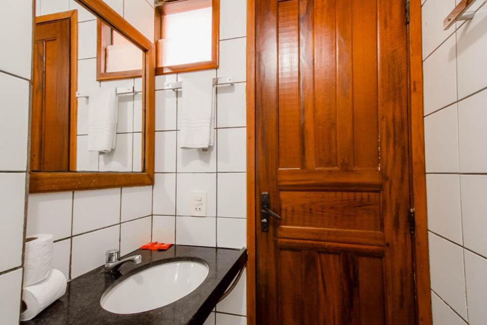 a bathroom with a sink and a wooden door at Porto Futuro Hotel in Fortaleza