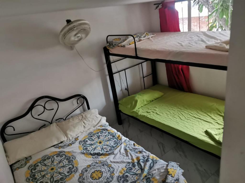 a room with two bunk beds and a bed with green sheets at Casa Acaritama 4 in Melgar