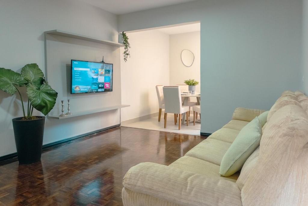a living room with a couch and a tv at Conforto e Localização TOP - MJ41 in Maringá