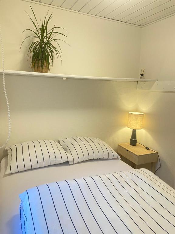 GedstedにあるÅlevænget 1のベッドルーム1室(ランプと植物付)
