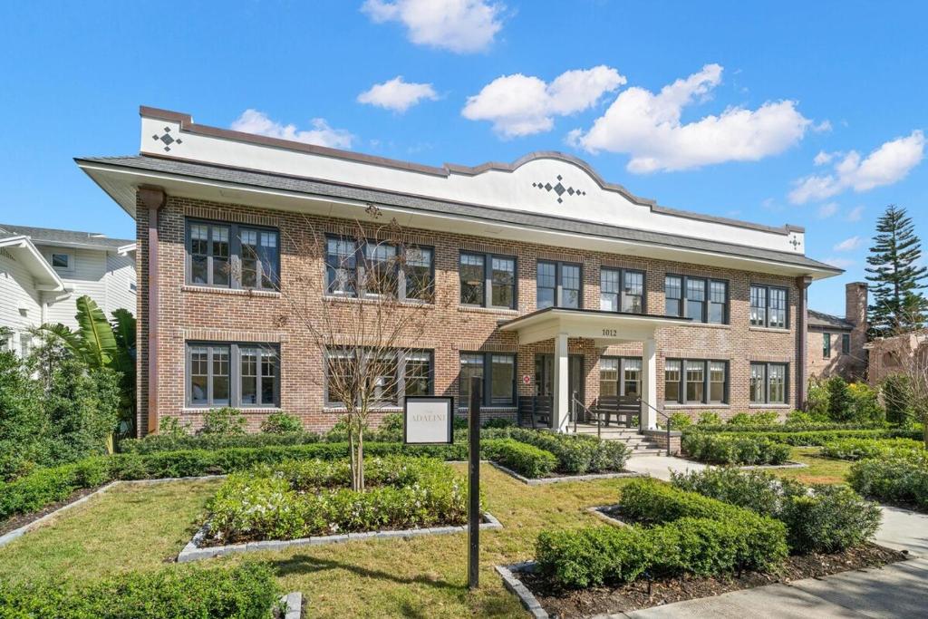 Un edificio de ladrillo con un jardín delante. en The Adaline - Entire Complex In Hyde Park, en Tampa