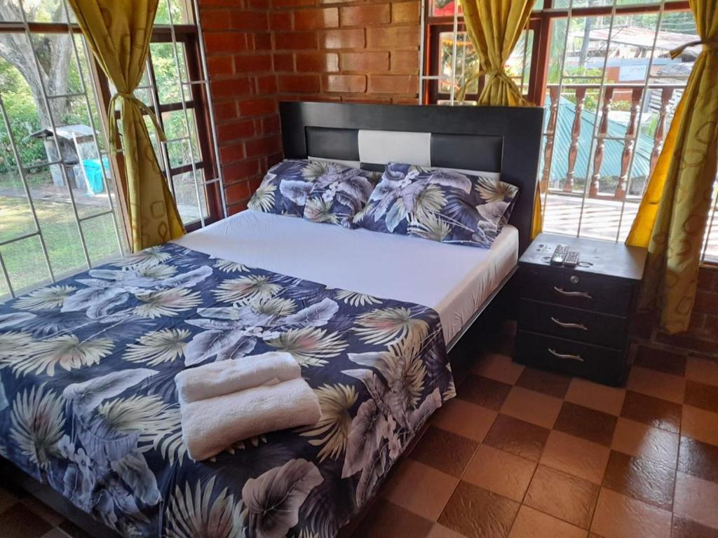 a bedroom with a bed with a blue and white comforter at Casa campestre el samán in Utica