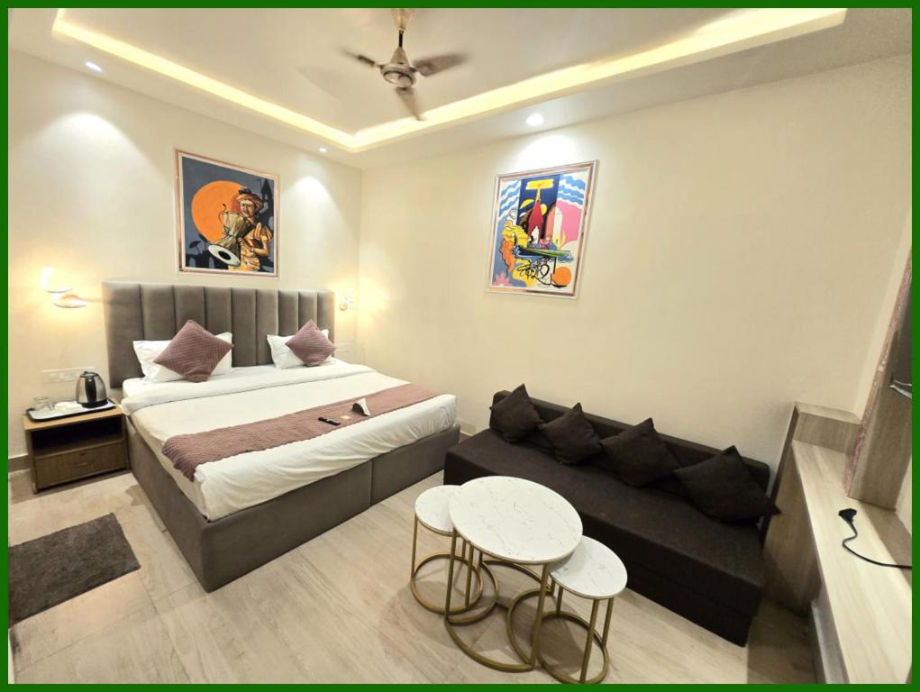 バラナシにあるV - PREMIUM BNR - INN - Free Wi-Fi & Parking - Near The Holy Kashi Vishwanath Templeのベッドとソファのある小さな寝室
