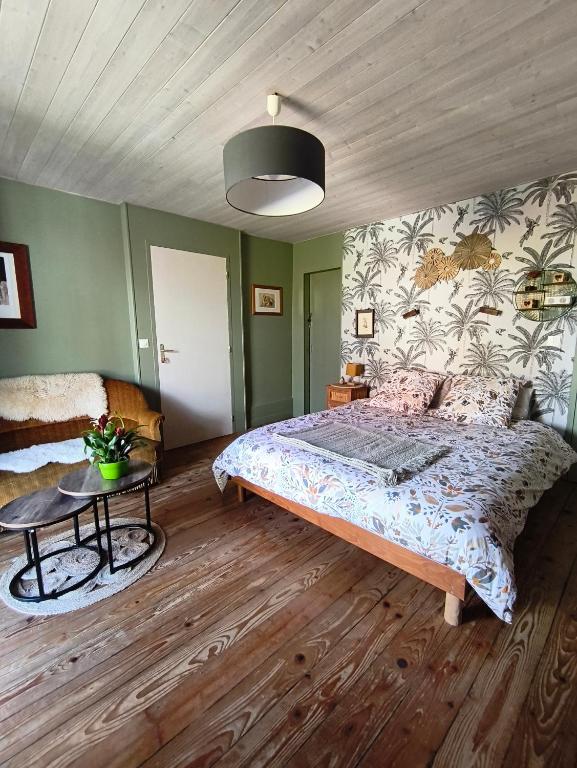 a bedroom with a large bed and a table at Le Balcon de Juliette in Vuillafans