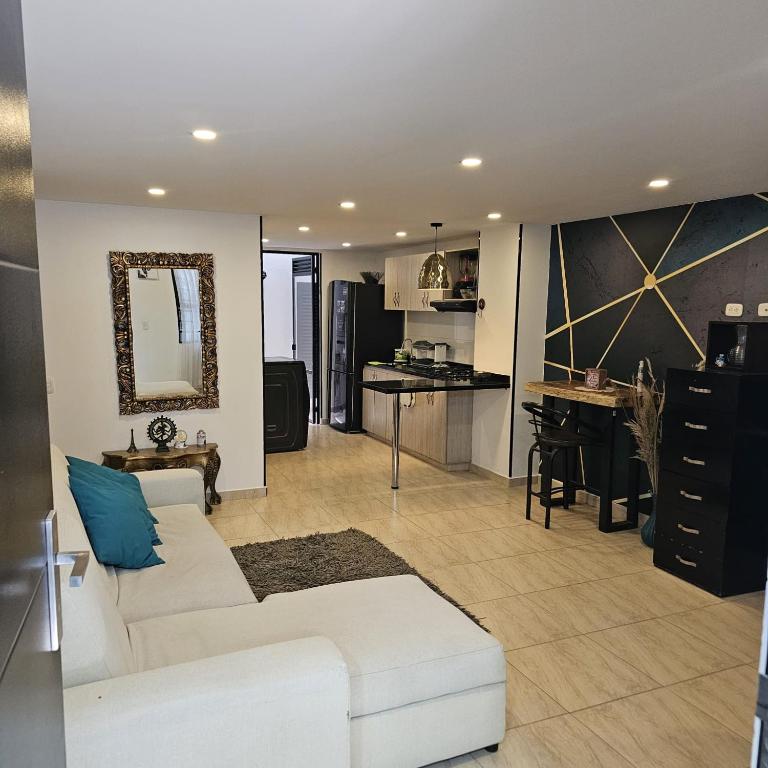 a living room with a white couch and a kitchen at Restrepo 201 in Bogotá