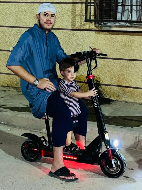 a man and a child on a scooter at Oran Canastel in Canastel