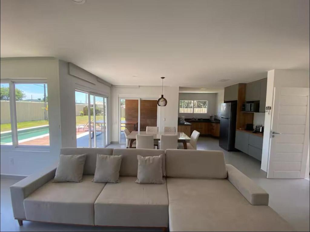 Una sala de estar con un sofá blanco y una cocina. en Buzios Heven, en Búzios