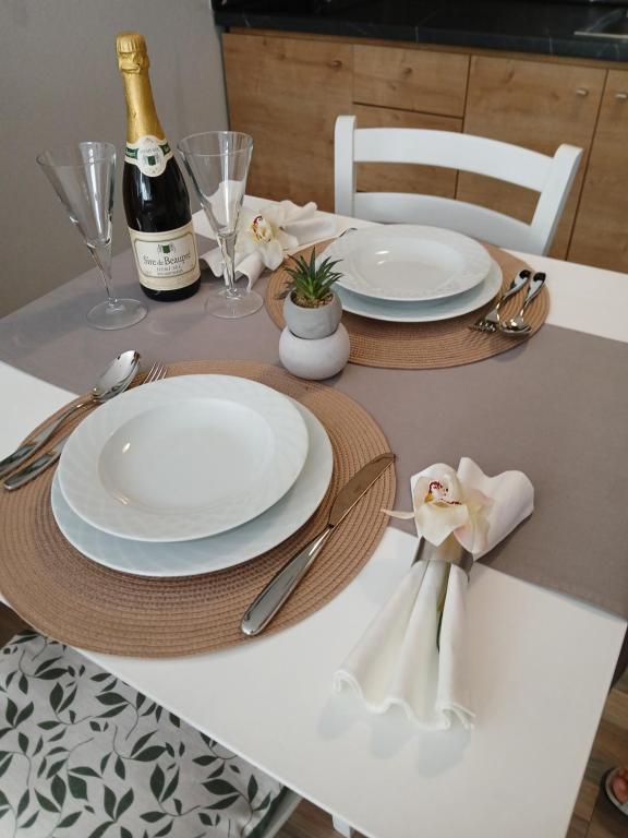 a table with white plates and a bottle of champagne at Luxury Spot Xanthi in Xanthi