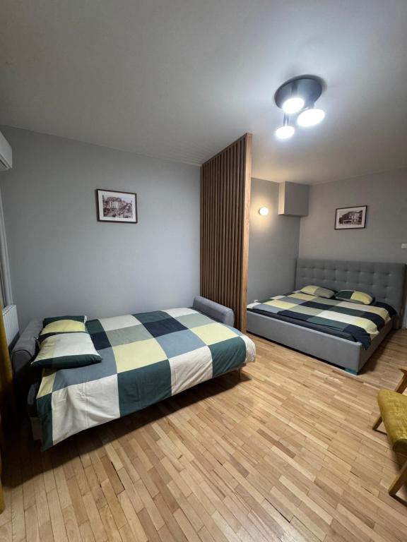 een slaapkamer met twee bedden in een kamer bij Double Studio near University Square - 2 Balconies in Boekarest