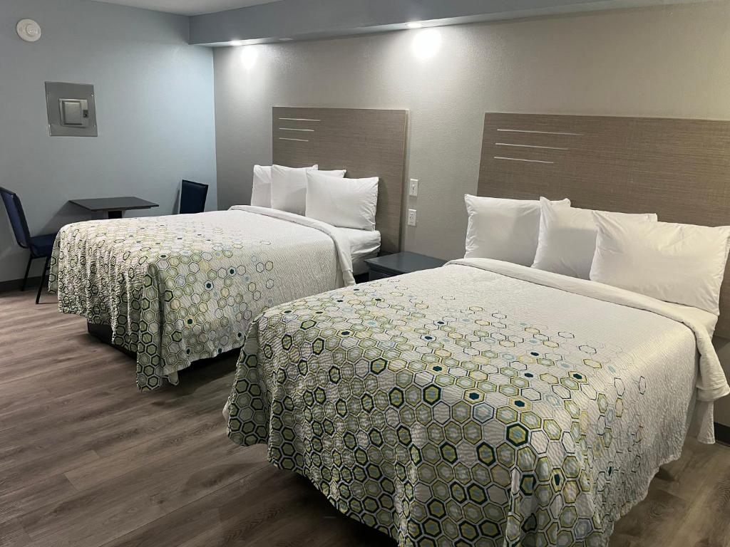 a hotel room with two beds with white sheets at HomeTowne Studios by Red Roof Athens, TN in Athens