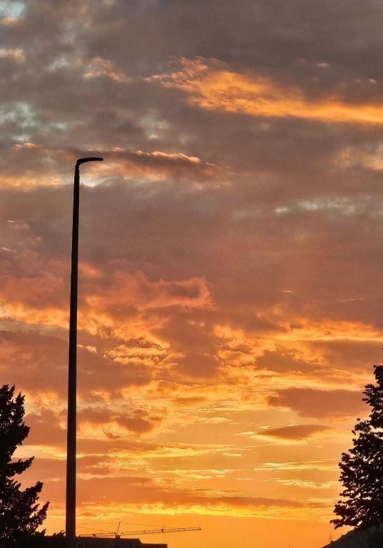 a street light in front of a sunset at Apartman Trebinje sa parkingom in Trebinje