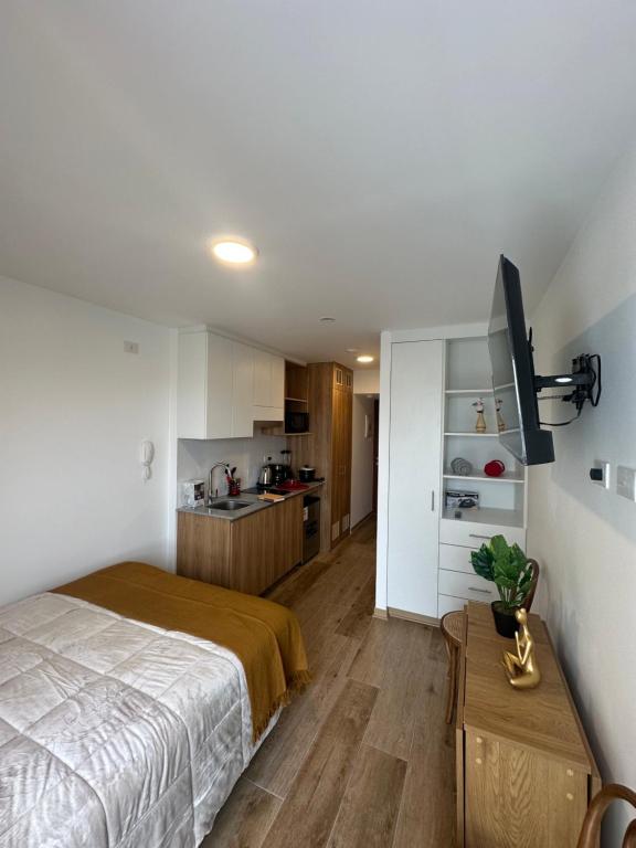 Un pequeño dormitorio con una cama y una cocina. en Vista Skyline en Piso 13 - Entre Lince y San Isidro, en Lima