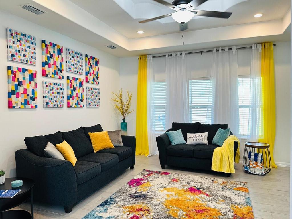 a living room with two couches and a ceiling fan at Quiet Cozy Spacious Stay w Private Pool in Brownsville