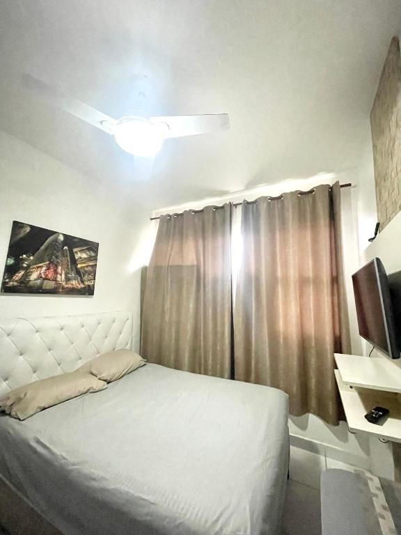 a bedroom with a white bed and a window at Alto Mar Studio in São Vicente
