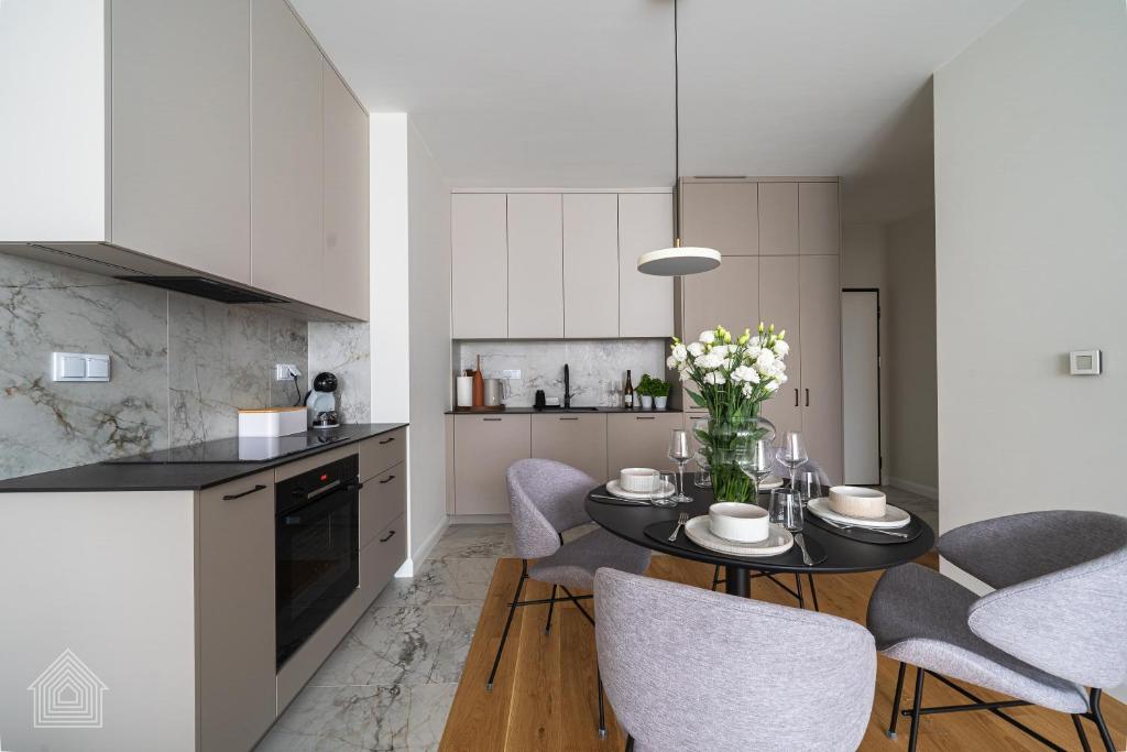 a kitchen and dining room with a table and chairs at Grzybowska Luxury Apartment with Skyline View by House Expert Warsaw in Warsaw
