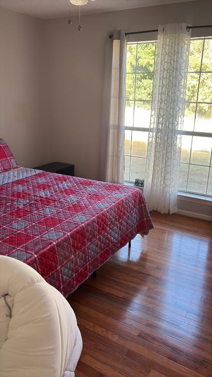 a bedroom with a bed with a red patterned blanket at Berni Oasis in Hampton