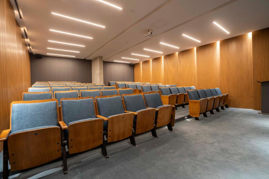 een lege collegezaal met blauwe stoelen erin bij Distrito Quartier Retiro in Buenos Aires