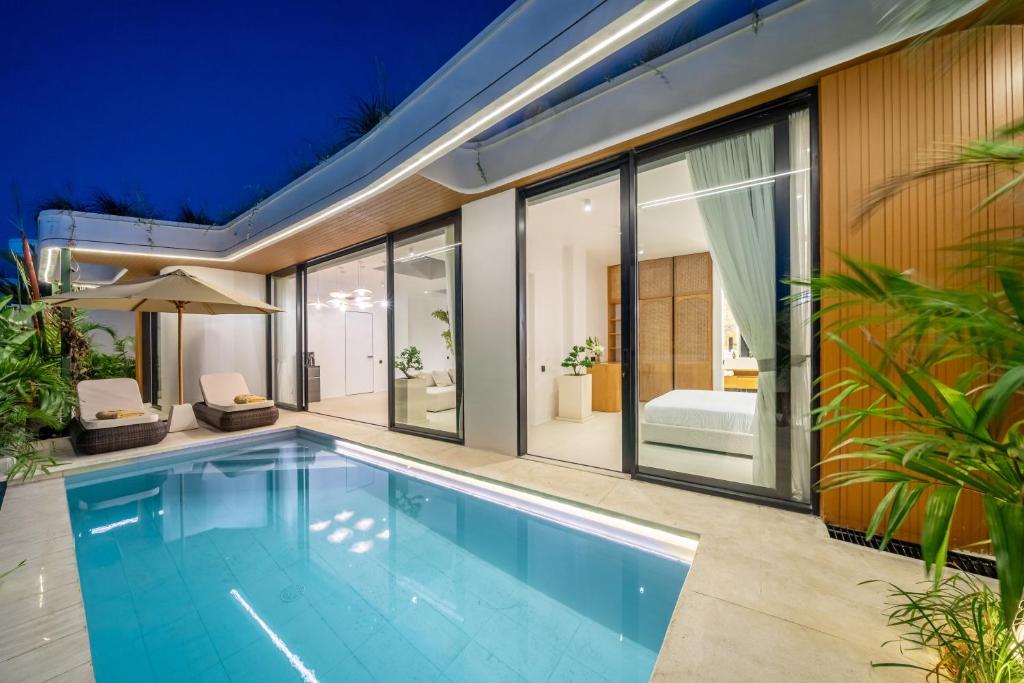 an indoor swimming pool in a house with glass walls at Ardhana 12 - Spacious and Stylish Villa - Pool - Full Kitchen - Netflix in Ungasan