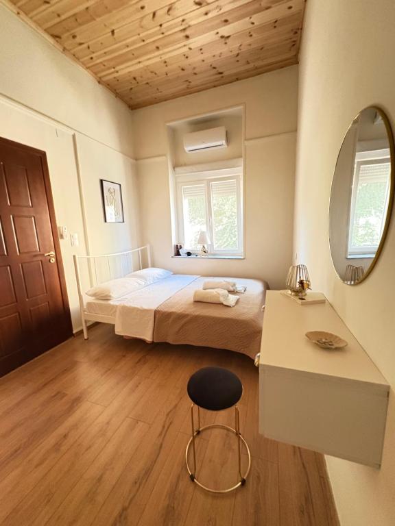 a bedroom with a bed and a mirror and a stool at MARY'S HOUSE - Urban Promenade Vibes in Tripolis