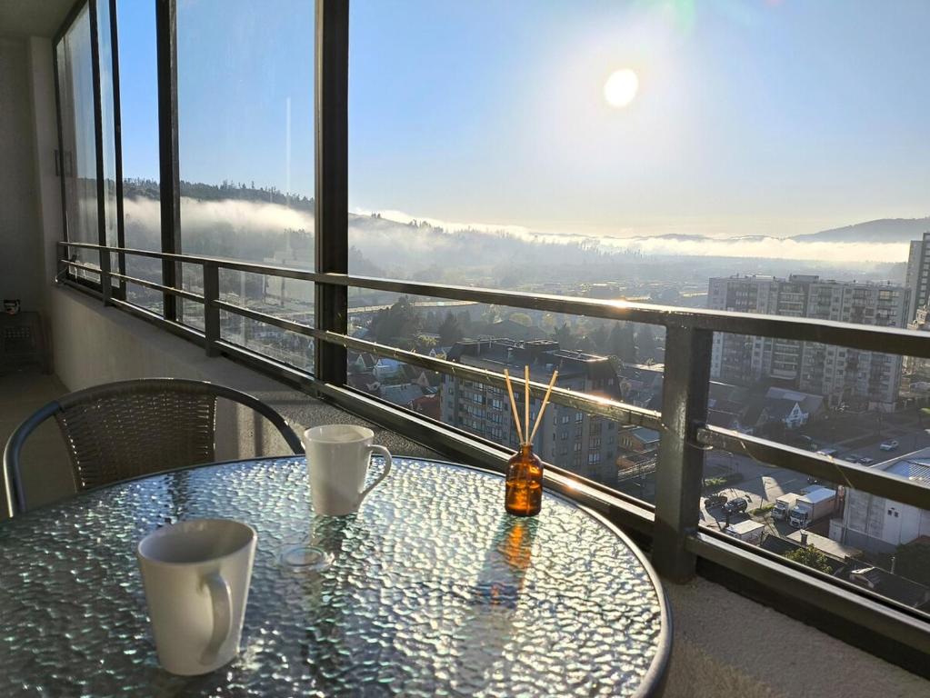 einen Tisch mit zwei Tassen auf dem Balkon in der Unterkunft Departamento NUEVO de 2 dormitorios con terraza en Concepción in Concepción